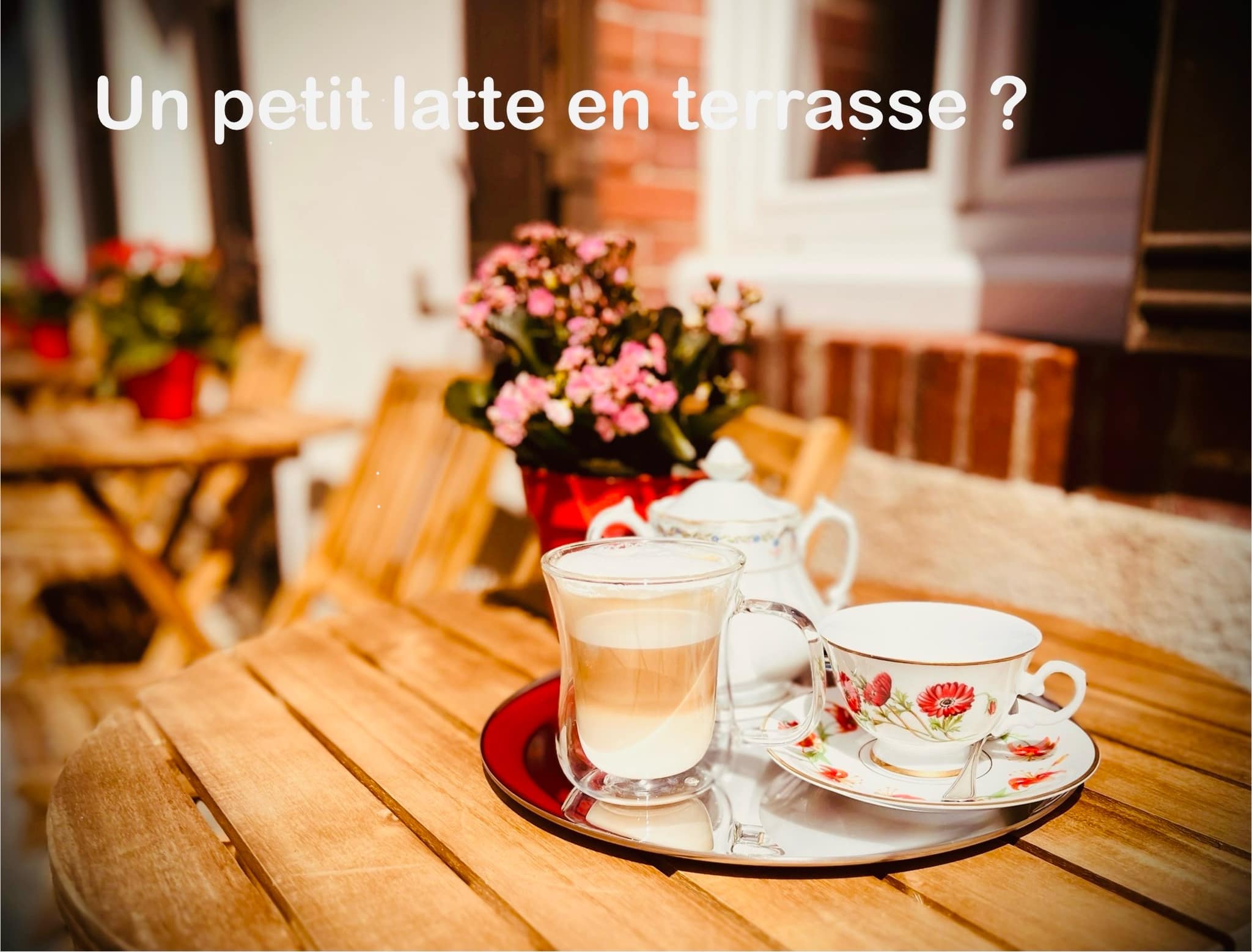 Café latte servi en terrasse avec tasse et pot à lait en porcelaine