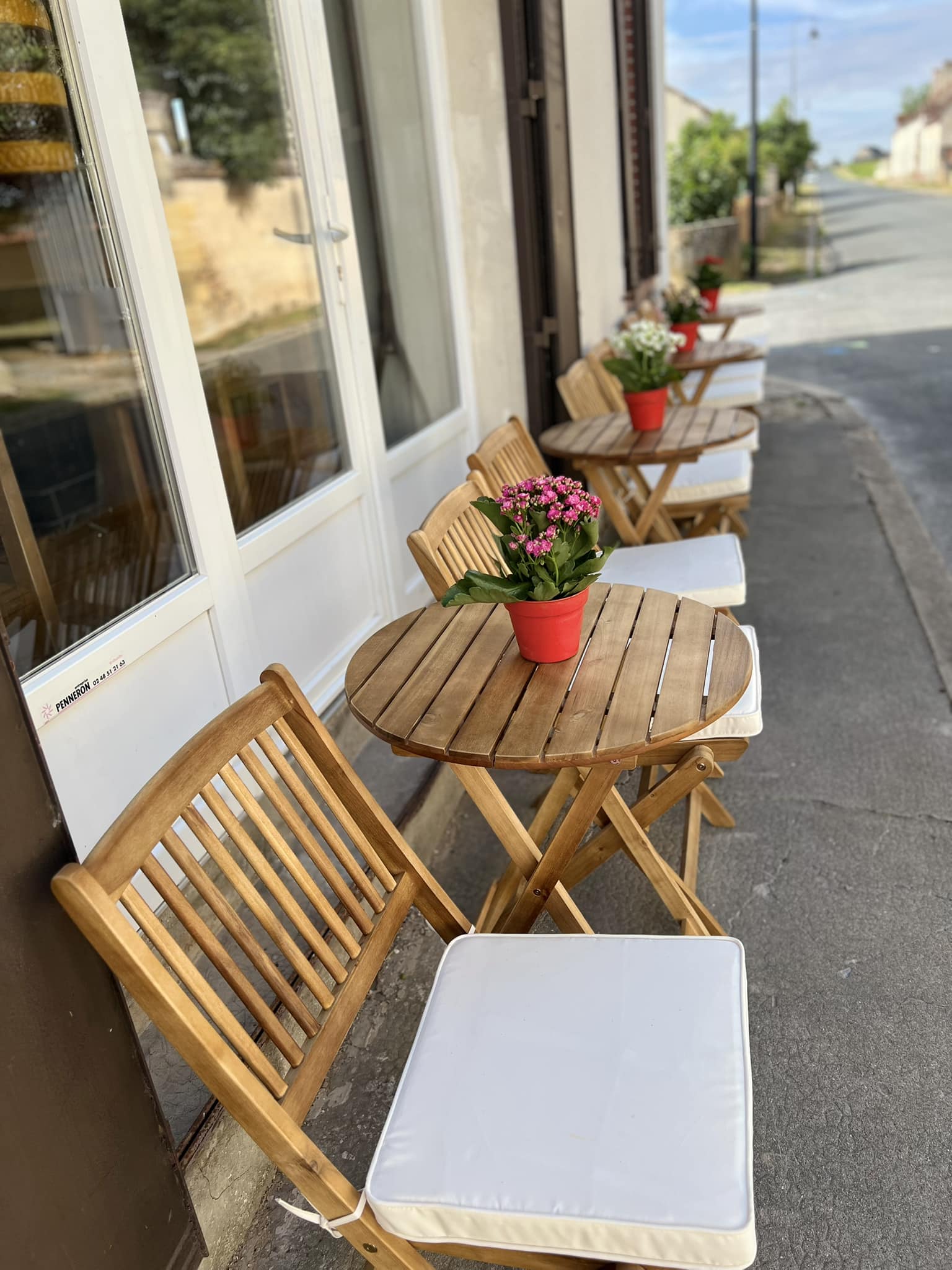 Terrasse ensoleillée avec tables et chaises en bois