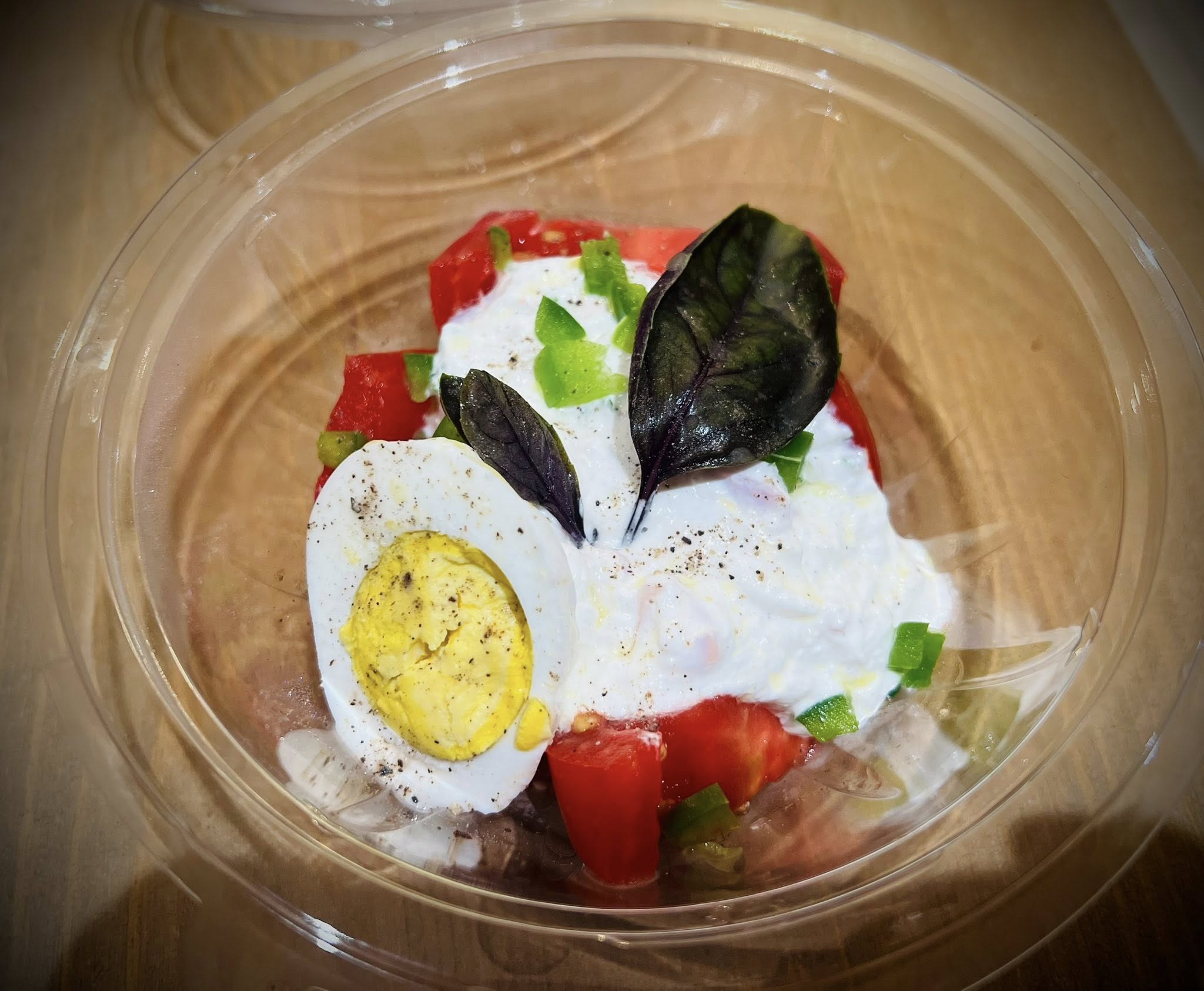 Barquette de salade tomates avec œuf mollet et herbes