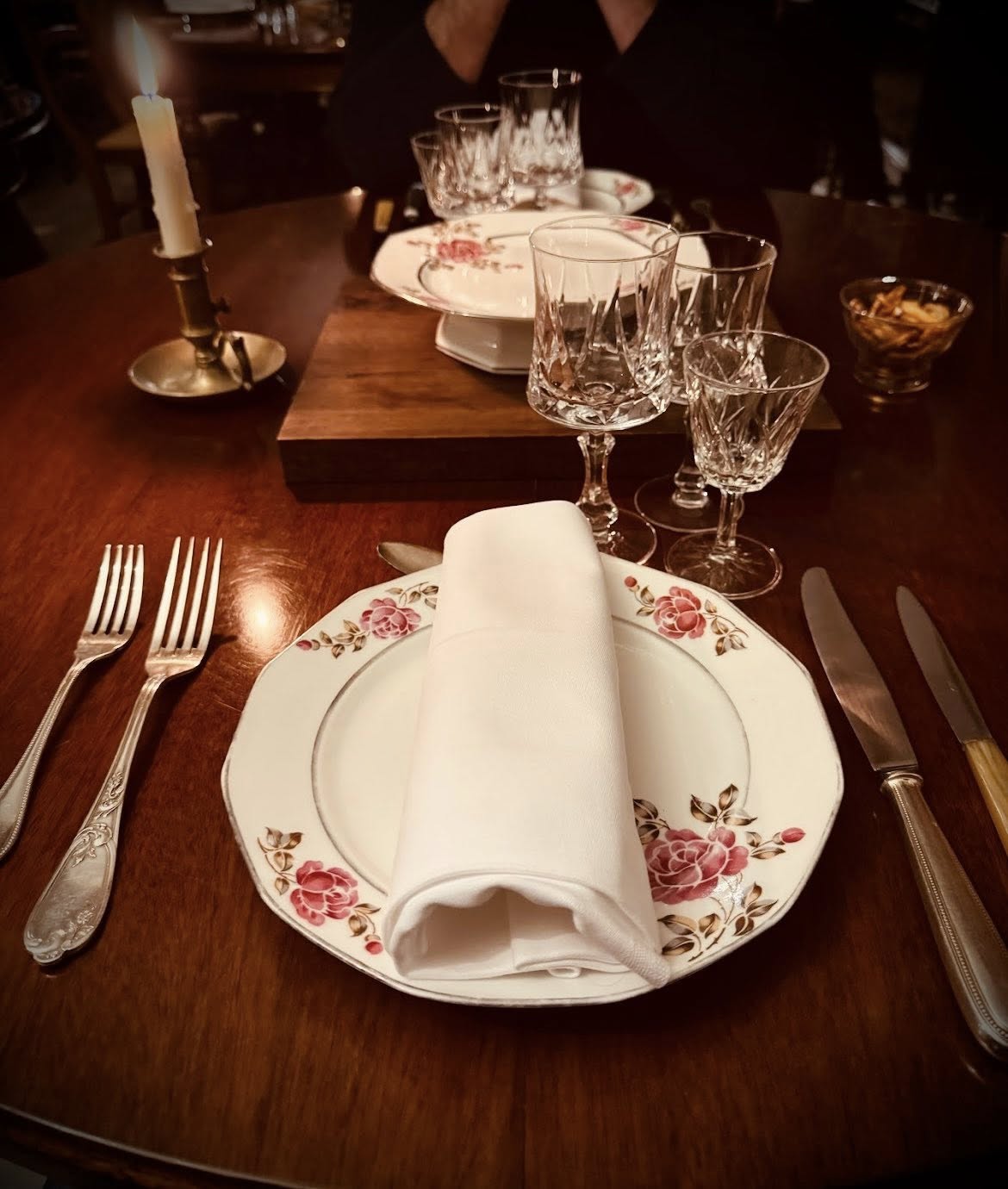 Table dressée avec bougies, fleurs et vaisselle de qualité — dîner privé